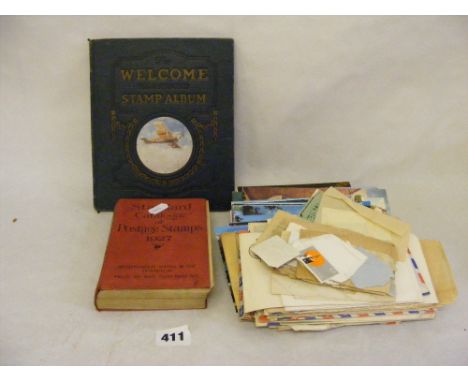 A 1927 postage stamp catalogue, a vintage stamp album and a folder of post cards, stamps etc.