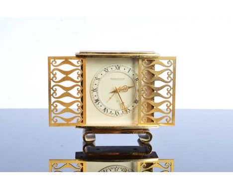 A c1960s Jaeger-LeCoultre alarm clock, 12.5cm high and 11.5cm wide, the gilt brass case with two sliding doors to front, mech