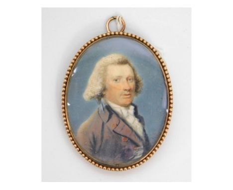 An 18thC. miniature portrait of a gentleman in purple coat &amp; white cravat, set in 9ct rose gold case with beaded border (