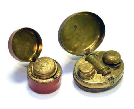 A Victorian morocco lined oval travelling inkwell or desk stand with hinged cover opening to reveal foliate engraved gilt met