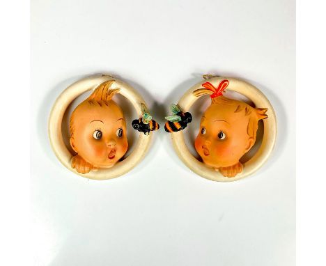 Pair of circular wall hangings depicting children surprised by a bee, one girl and one boy. M.J Hummel imprint and item numbe
