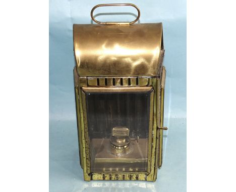 A vintage brass oil lamp, the domed top with ring handle and three glazed side panels enclosing oil lamp, 39cm high, 18cm wid