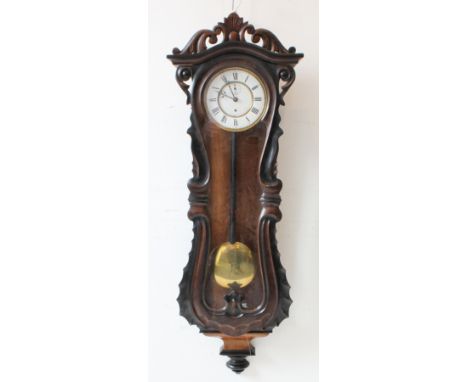 A large 19th century walnut-cased continental Vienna regulator-style wall-hanging clock: the foliate carved and pierced pedim