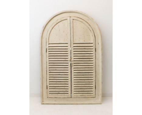 A large arch-shaped mirror set in a conforming frame with two louvre doors painted in shabby-chic style.&nbsp;(151 cm high x 