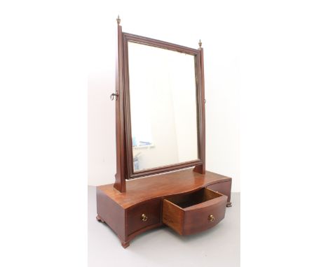A George III period mahogany-framed toilet mirror: the plate flanked by two vertical uprights terminating in neoclassical-sty