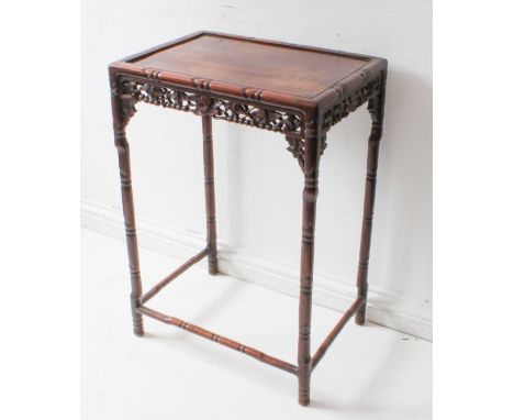 A late 19th to early 20th century Chinese hardwood occasional table: recessed top bordered by faux bamboo carving above pierc