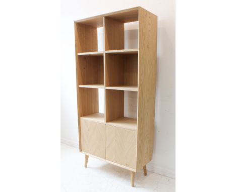 A modern oak shelf unit by Gallery Ltd: half-width square shelves and two cupboard doors below; raised on slightly splaying t