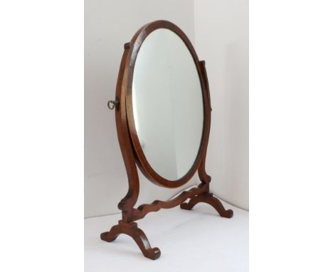 A George II oval mahogany and boxwood-strung toilet mirror raised on shaped base (40.5 cm wide x 58.5 cm high)