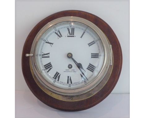 An early 20th century eight-day ship's bulkhead clock (with modern replaced quartz movement) mounted on a conforming circular