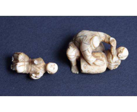 A 19th Century Japanese carved ivory netsuke of a seated figure and a similar smaller figure (both a/f)