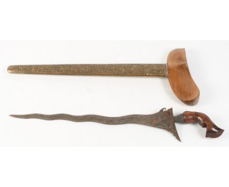 An Indonesian kris with carved hardwood handle and embossed brass scabbard, 20" long overall