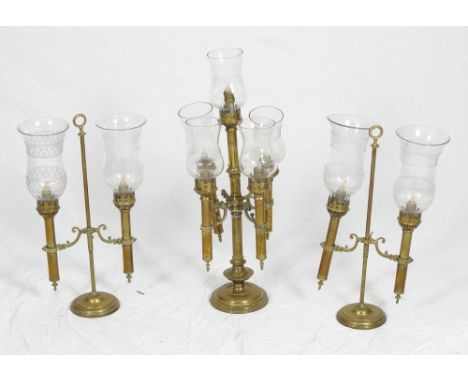 A pair of 19th Century brass two-light candlesticks with engraved glass shades and a companion five-light centre candlestick 