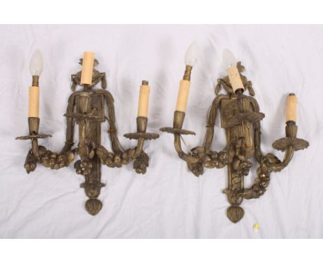 A pair of early 19th Century brass three-light wall brackets with floral decoration, 16" high, and a smaller similar two-ligh