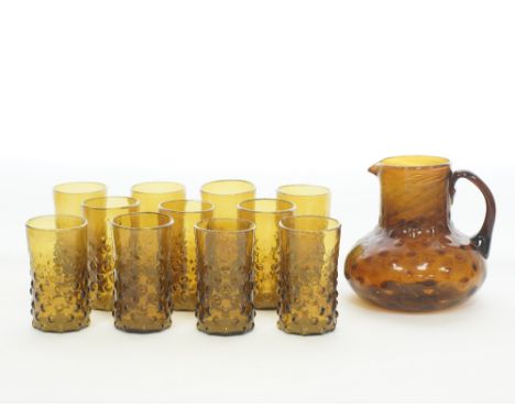 A Syrian Salaheddin, set of eleven water glasses and a pitcher made of amber hand blown glass with spotted bubble roundels. T