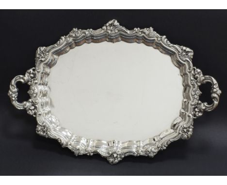 An oval serving tray W60cm, D41cm with ornate handles and surround with a raised Chippendale edge and external rococo decorat