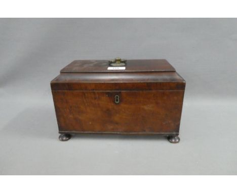 19th century mahogany sarcophagus tea caddy, the hinged lid opening to reveal three division, on bun feet, 29 x 18cm 