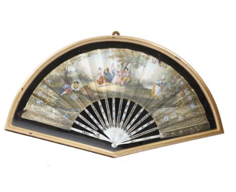 A continental painted and gilt fan, the leaf decorated with a woodland scene of figures dancing and playing music before a la