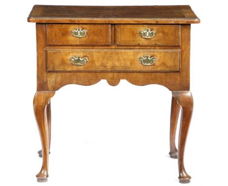 A George II walnut lowboy, cross and feather banded, the quarter veneered top with a caddy moulded edge, above three drawers,