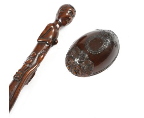 A folk art carved wood naive walking cane, the handle in the form of a native with a sliding cover revealing a snuff compartm