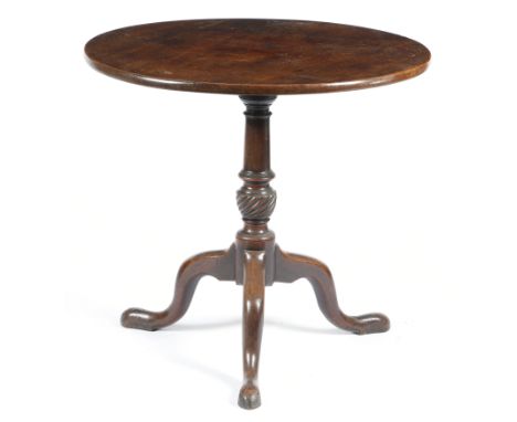 A George III mahogany tripod table, the circular tilt-top above a ring turned baluster stem with a fluted bowl, on cabriole l
