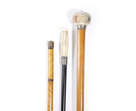 λ Three novelty 'system' walking canes, comprising: a sectional cane with brass mounts, which unscrews to reveal a nib, a pen