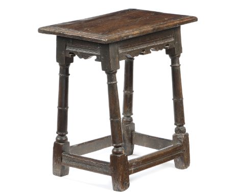A Charles I oak joint stool, the seat with a triple moulded edge, above moulded and twin bicuspid rails, on slender ring turn