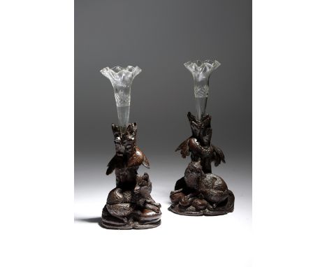A near pair of late 19th century Black Forest carved wood epergnes, each with a glass vase, inset into a naturalistic base ca