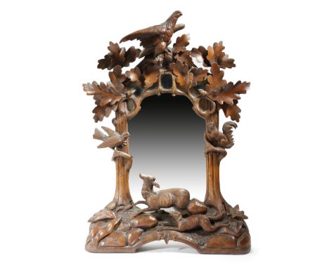 A late 19th century Black Forest wall mirror, the shaped plate within a naturalistic frame carved with a deer pursued by a hu
