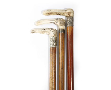 Three Malacca walking canes, each with a carved bone handle, one in the form of a boot, with a silver ferrule inscribed 'T. W