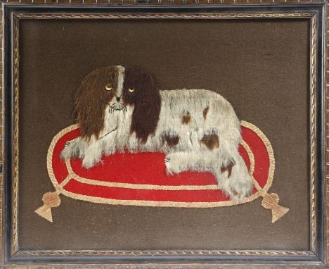 A Victorian felt picture of a spaniel, seated on a tasselled cushion, the verso with a hand-written paper label, inscribed 'P