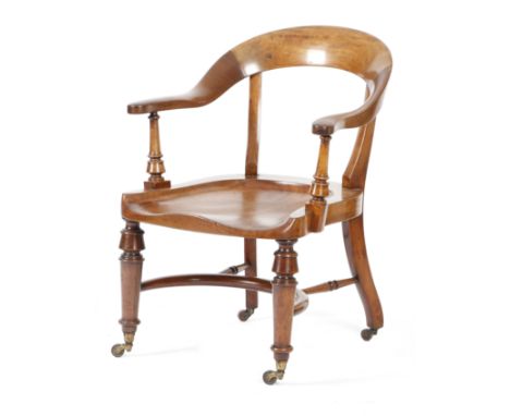 A Victorian mahogany captain's chair by Bartholomew, with a curved top rail and a dished seat, on turned front legs united by