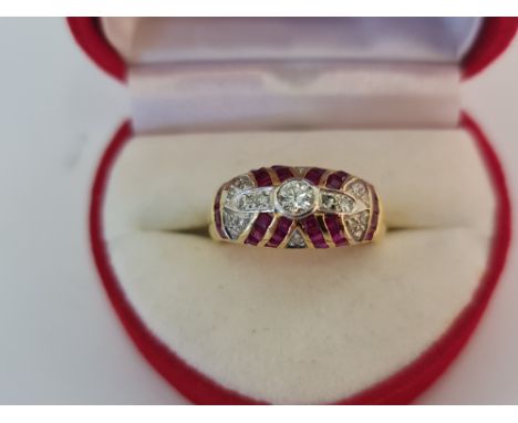 A stamped18k cluster ring, central diamond surrounded by ruby baguettes and accent diamonds, ring size K.