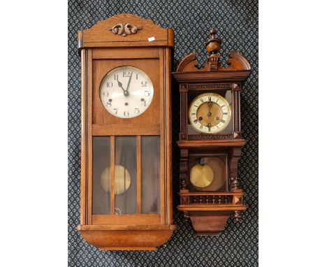 A walnut cased wall clock together with a oak cased wall clock.