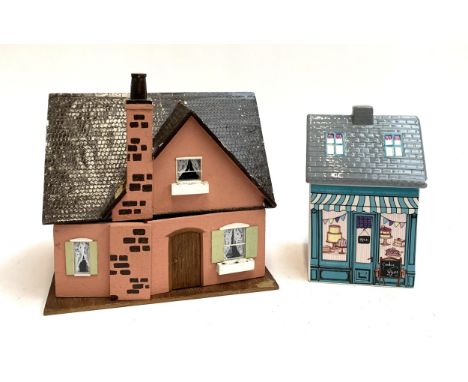 A small dolls house, 31cmW, with contents together with a small ceramic biscuit jar in the form a house 