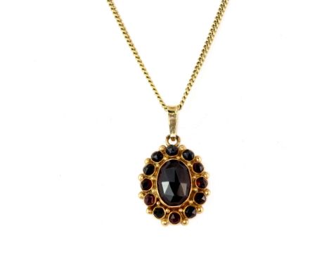 A 14ct yellow gold chain with a yellow metal (tested minimum 9ct gold) garnet set pendant, L. 42cm.