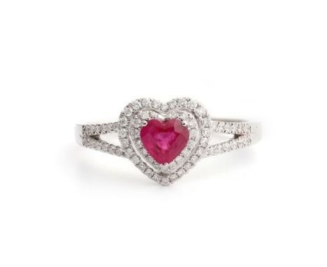 An 18ct white gold (stamped 750) ring set with a heart brilliant cut ruby surrounded by diamonds and diamond set shoulders, (