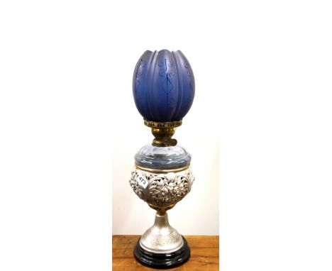 An unusual 19th century silvered cast metal oil lamp with etched blue glass shade, overall H. 64cm.
