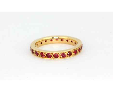 A 14ct yellow gold (worn stamp 585) ruby set full eternity ring, (K).