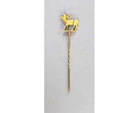 A cased early 20th century yellow metal stag stick pin, 77mm, 4.3 grams (a.f.).