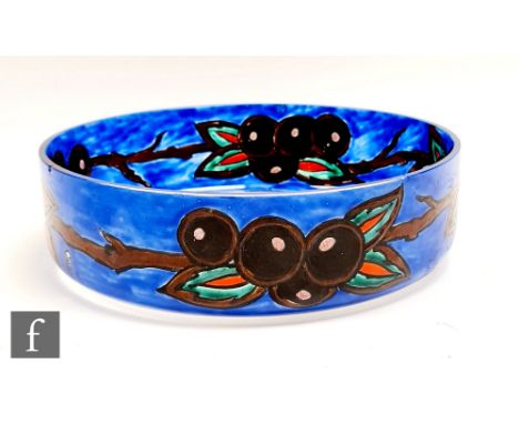 A 1920s Leune glass bowl of high sided circular section, enamel decorated with leaves and berries against a blue ground to th