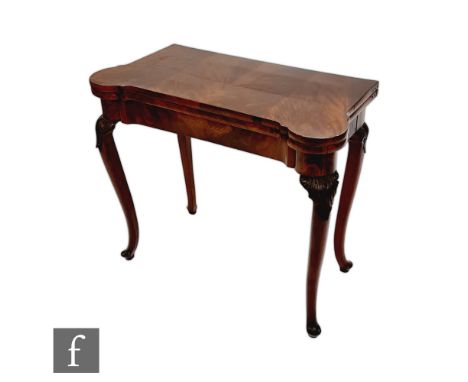 A George III mahogany fold-over card table, the baize lined top with candle reserves to the corners and with counter wells, a