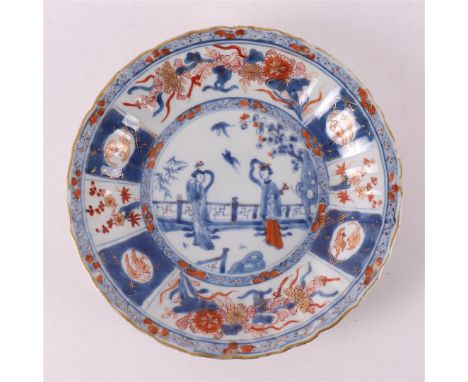 A porcelain Chinese Imari contoured plate, China, Kangxi, around 1700. Blue/red, partly gold-heightened decoration of figures