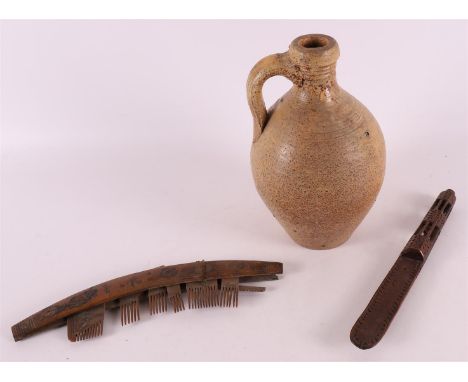 A gres stoneware jug, 17th century, h 21.5 cm. Wooden knitting sheath and comb (damaged), tot. 3x.
