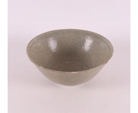 A celadon porcelain bowl on a stand ring, China 16th century. Engraved decor on the inside, h 8x Ø18.5 cm (fritting).