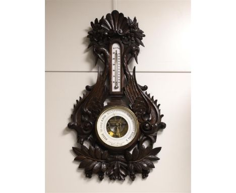 An aneroid barometer in softwood case, Germany, around 1900. Decorated with grape vines and swans, h 79 cm.