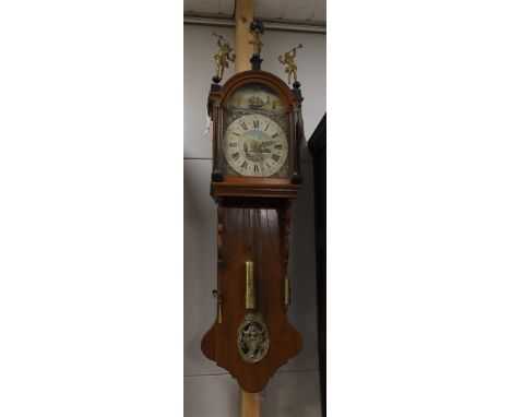 A Frisian model tail clock, 19th century. Oak case, the double hood is crowned with Atlas and trumpet-blowing angels, pilaste