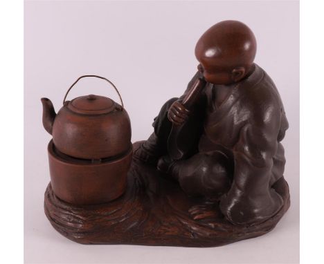 A Yixing stoneware sculpture of a boy lighting a tea fire, China, 1st half 20th century. Marked with seal mark on the side, h