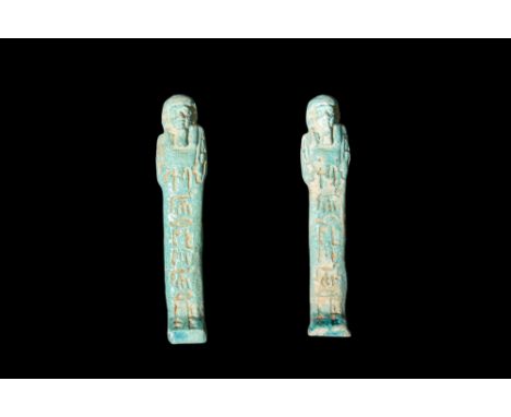 Late Period, 30th Dynasty, Ca. 332 BC.A pair of light blue faience ushabti figures, each adorned with a column of hieroglyphs