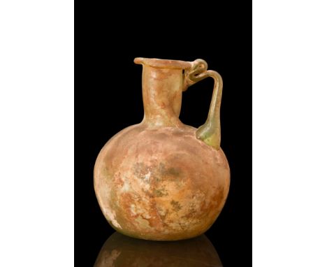 Ca. 1st-2nd Century AD.A Roman glass bottle of a light yellow-green colour with warm orange encrustation. The vessel has a tu