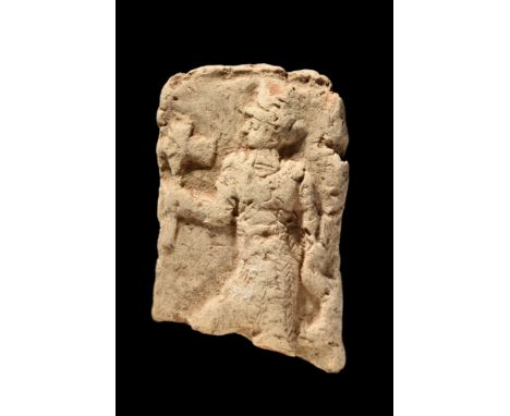 Ca. 2000-1600 BC.A pottery plaque with a low relief depiction of a left-facing male figure wearing a long kilt and holding a 
